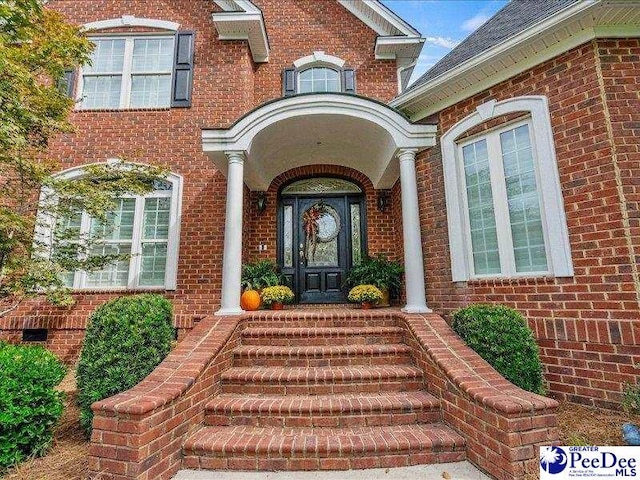 doorway to property with brick siding