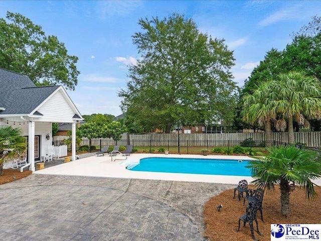 view of swimming pool featuring fence, a fenced in pool, and a patio