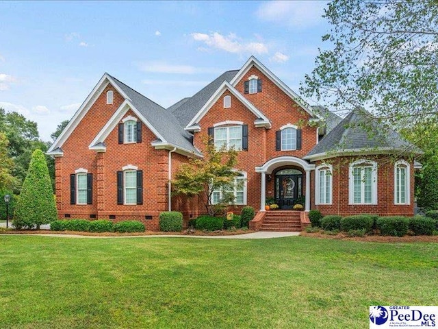 view of front of property with a front yard, crawl space, brick siding, and roof with shingles