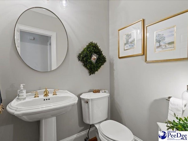 bathroom featuring toilet and baseboards