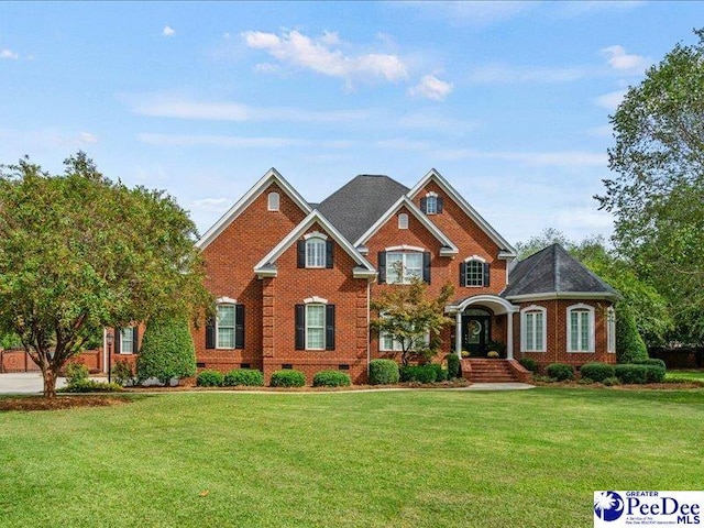 view of front facade with crawl space, a front lawn, and brick siding