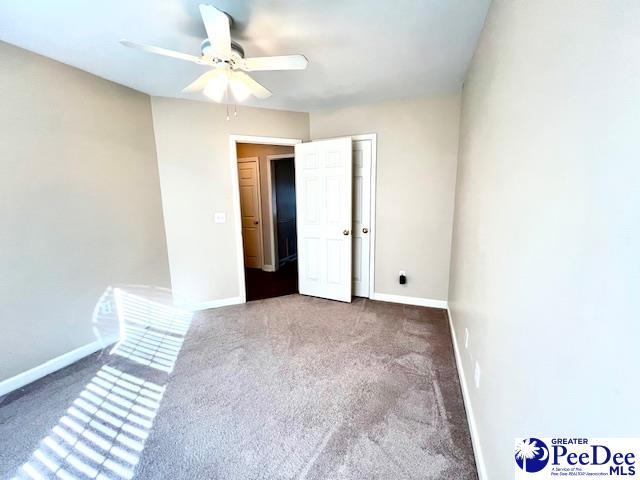 3014 Longfellow Dr, Florence, SC 29505 - spare room featuring ceiling fan and dark carpet