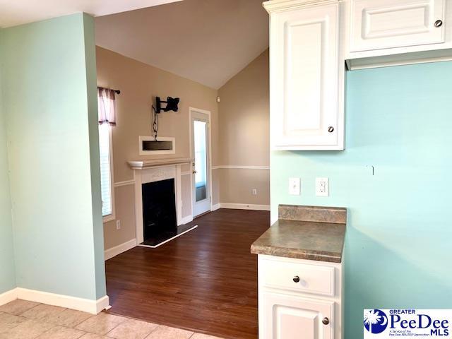 3014 Longfellow Dr, Florence, SC 29505 - kitchen featuring white cabinetry, vaulted ceiling, and light tile patterned floors