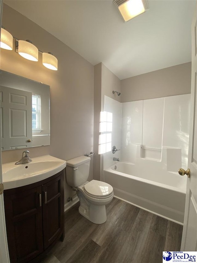 full bathroom with vanity, hardwood / wood-style floors, toilet, and washtub / shower combination