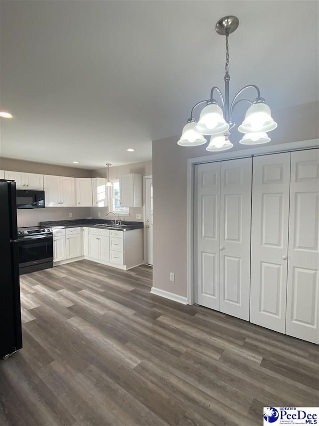 kitchen featuring decorative light fixtures, dark wood-type flooring, black appliances, and white cabinets