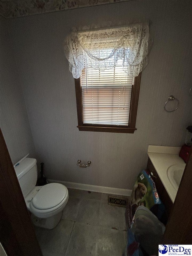 bathroom featuring tile patterned floors, baseboards, toilet, and vanity