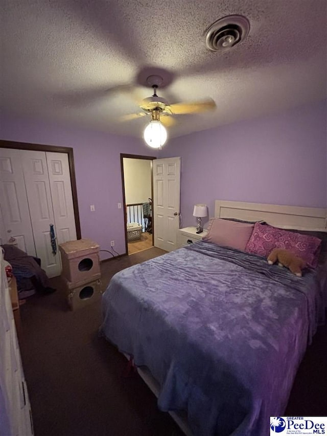 bedroom featuring visible vents, carpet flooring, a textured ceiling, and a ceiling fan