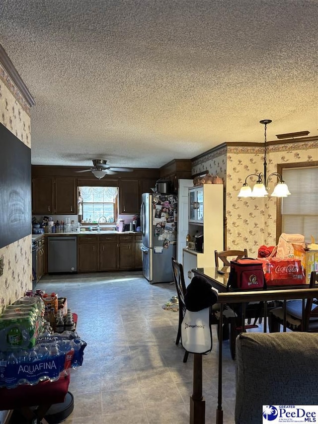 dining space featuring wallpapered walls, ceiling fan with notable chandelier, and a textured ceiling