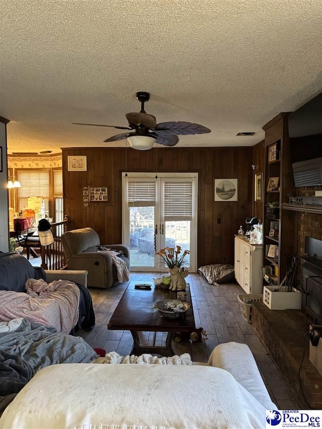 living area featuring a textured ceiling, dark wood-style floors, and a ceiling fan