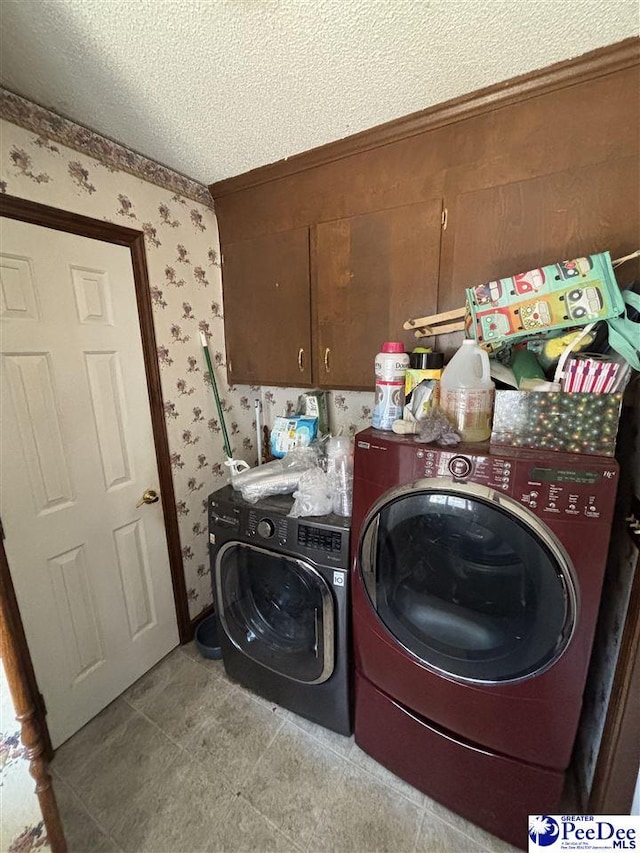 clothes washing area featuring cabinet space, independent washer and dryer, a textured ceiling, and wallpapered walls