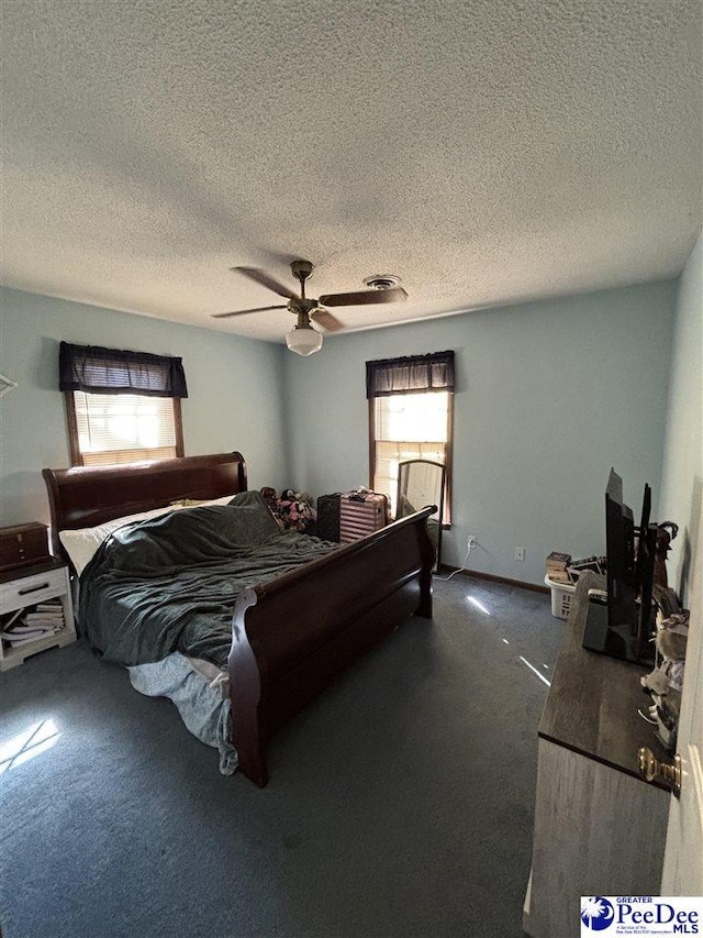 bedroom with visible vents, baseboards, a textured ceiling, and a ceiling fan