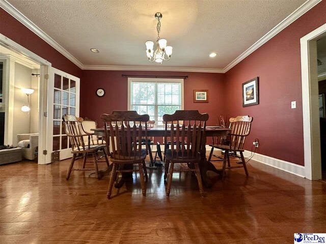 dining space with ornamental molding, a notable chandelier, and a textured ceiling