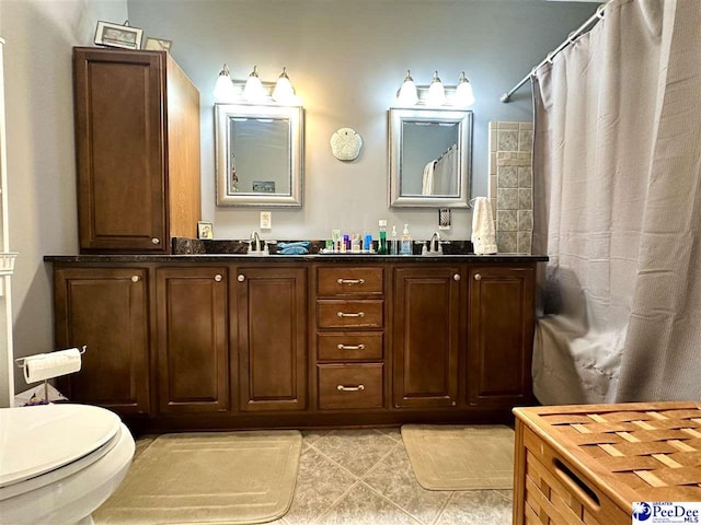 bathroom with tile patterned flooring, vanity, toilet, and walk in shower