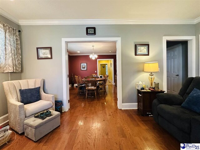 interior space featuring a notable chandelier, hardwood / wood-style flooring, and ornamental molding