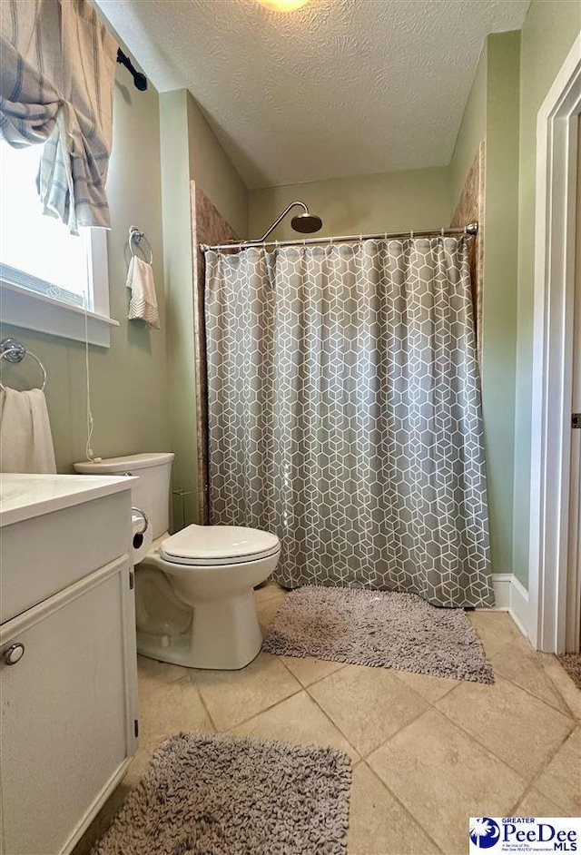 bathroom with vanity, toilet, tile patterned floors, a textured ceiling, and a shower with curtain