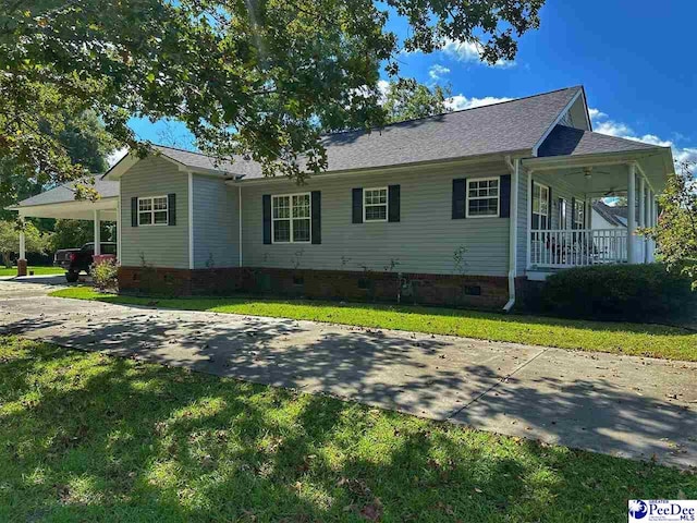 view of home's exterior with ceiling fan, a carport, covered porch, and a lawn