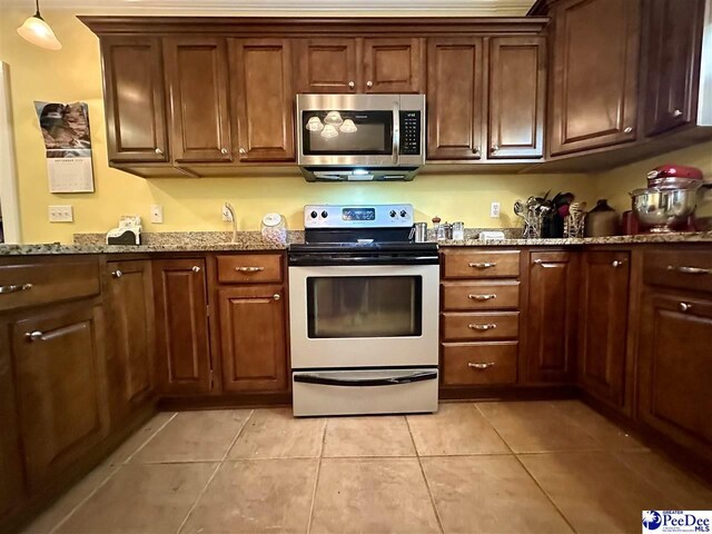 kitchen featuring stainless steel appliances, decorative light fixtures, stone countertops, and light tile patterned floors