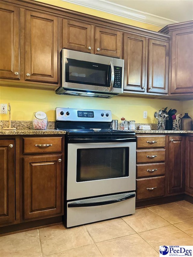 kitchen with stainless steel appliances, light tile patterned flooring, stone countertops, and crown molding