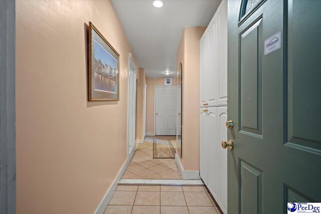 hall featuring light tile patterned flooring