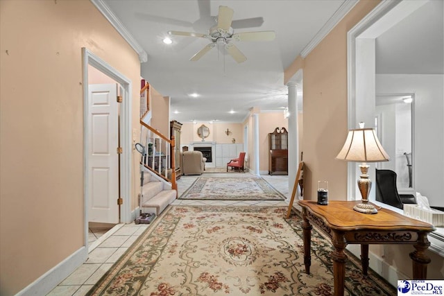 hall featuring crown molding, ornate columns, and light tile patterned floors