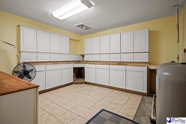 kitchen with white cabinetry, built in desk, and light tile patterned floors