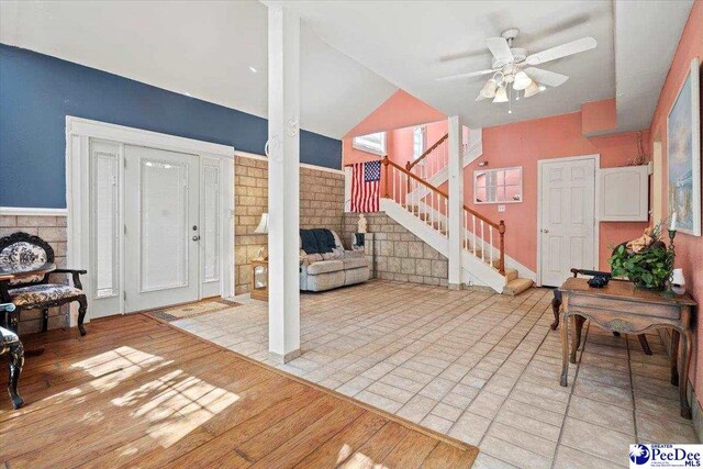 living room with lofted ceiling, light hardwood / wood-style flooring, and ceiling fan