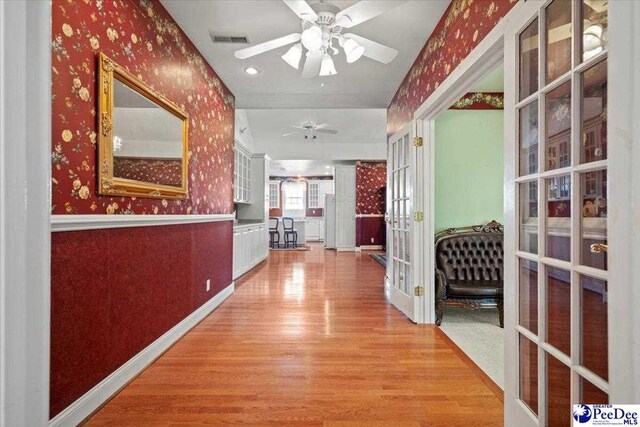 corridor featuring french doors and light hardwood / wood-style floors