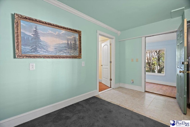 tiled foyer entrance featuring crown molding