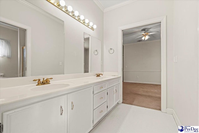 bathroom with double vanity, ornamental molding, a sink, and baseboards