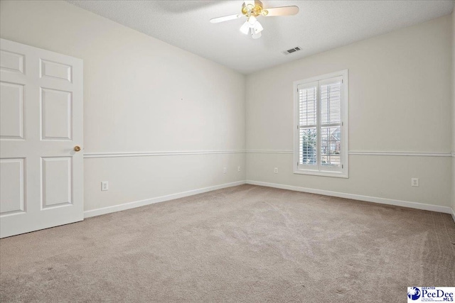 spare room with light colored carpet, visible vents, and baseboards