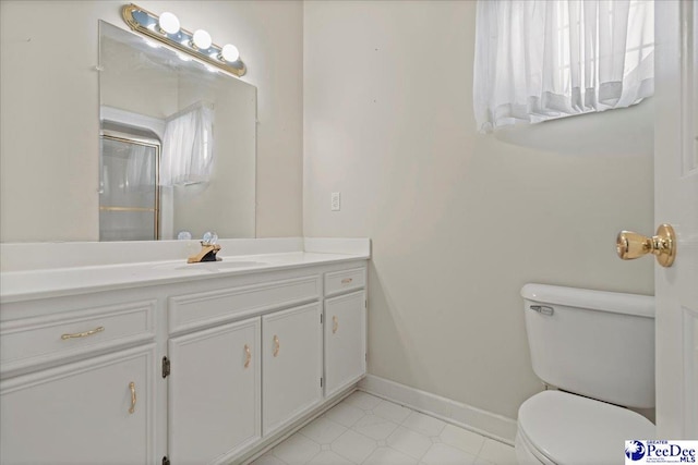 bathroom with toilet, vanity, and baseboards