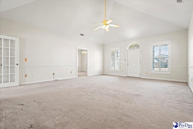 unfurnished living room featuring baseboards, plenty of natural light, lofted ceiling, and light colored carpet