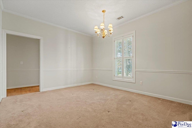 spare room with light carpet, ornamental molding, visible vents, and an inviting chandelier