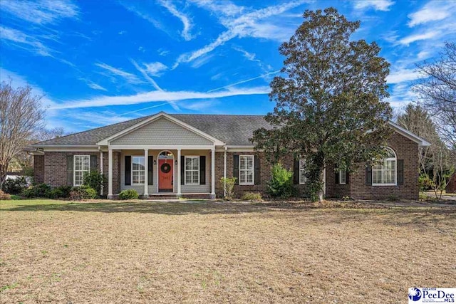 ranch-style house with a front yard, a porch, and brick siding