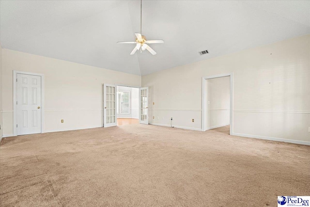 carpeted spare room with ceiling fan, high vaulted ceiling, visible vents, baseboards, and french doors