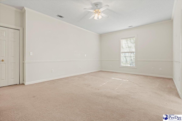 spare room with light carpet, visible vents, and crown molding