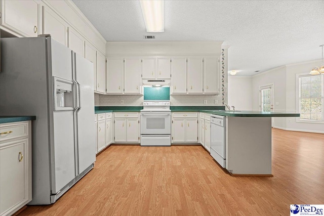 kitchen featuring under cabinet range hood, white appliances, visible vents, white cabinetry, and dark countertops