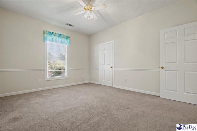 interior space featuring baseboards, visible vents, light carpet, and a textured ceiling