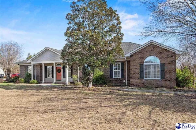 ranch-style home featuring brick siding and a front lawn