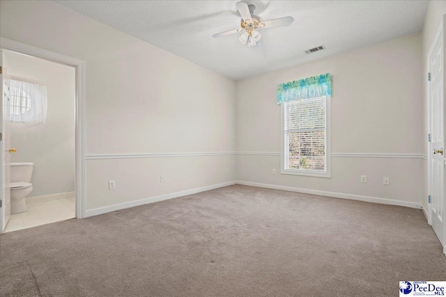 unfurnished bedroom with light carpet, multiple windows, visible vents, and a textured ceiling