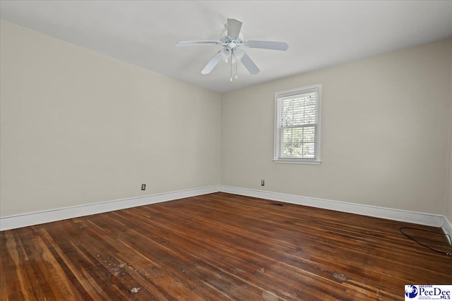 empty room featuring baseboards, a ceiling fan, and dark wood-type flooring