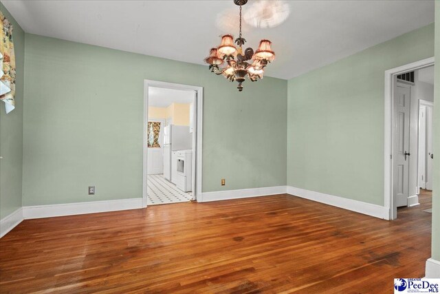 unfurnished dining area with a chandelier, wood finished floors, and baseboards