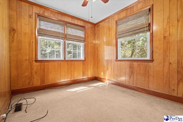 empty room featuring a healthy amount of sunlight, carpet flooring, and ceiling fan