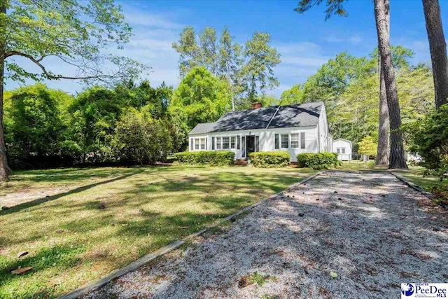 view of front of property featuring a chimney and a front yard
