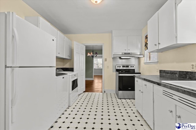 kitchen featuring washing machine and clothes dryer, stainless steel electric range, white cabinetry, under cabinet range hood, and freestanding refrigerator