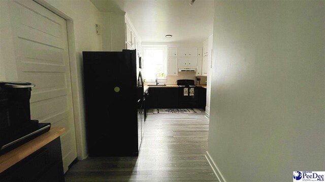 kitchen featuring hardwood / wood-style flooring, white cabinetry, and black appliances