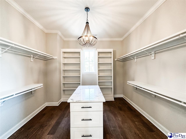 spacious closet with dark wood-style floors and a chandelier