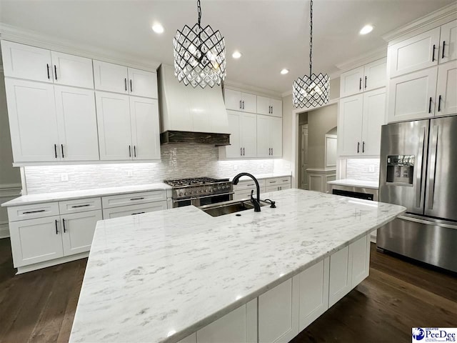 kitchen with stainless steel appliances, white cabinets, decorative light fixtures, and a sink