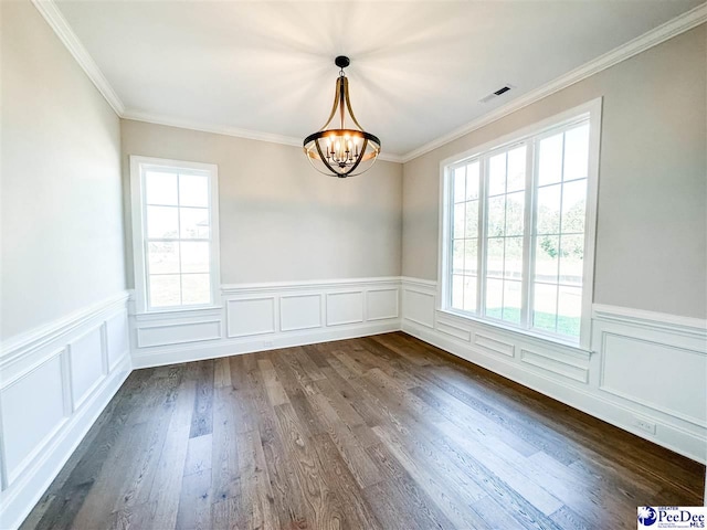 unfurnished dining area with visible vents, a wainscoted wall, ornamental molding, dark wood-style flooring, and a notable chandelier