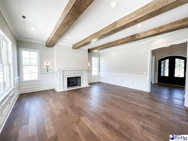 unfurnished living room featuring visible vents, dark wood finished floors, french doors, a fireplace, and beam ceiling